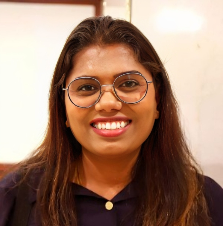 A smiling woman with glasses wearing a black shirt.