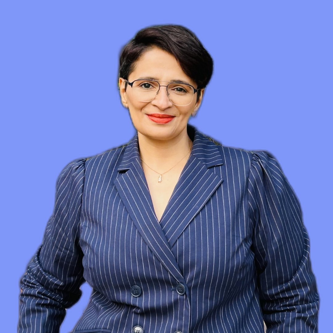 A professional woman in a stylish blue pinstripe suit wearing glasses.